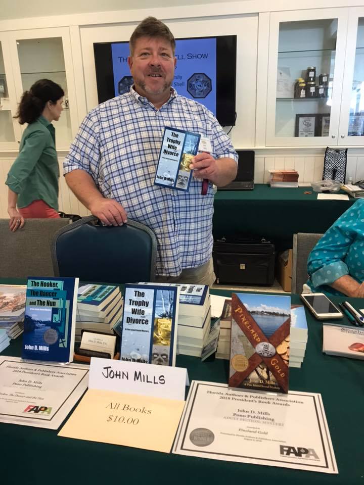 A man holding up an item at a book fair.